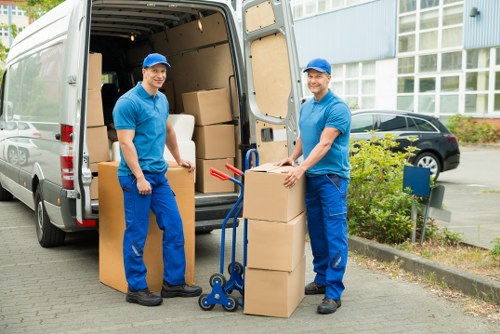 Moving crew unloading furniture into a home in Ealing